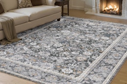 Black and floral area living room rug on hardwood floors with couch.