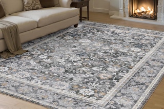 Black and floral area living room rug on hardwood floors with couch.