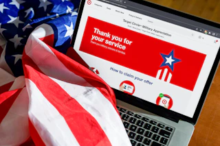 An American flag draped over a laptop displaying the Target webpage for their military discount program