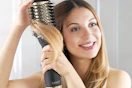 woman using a hair dryer blow brush