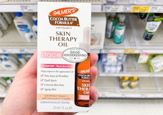 hand holding bottle of palmer's skin therapy face oil with retinol and vitamin c