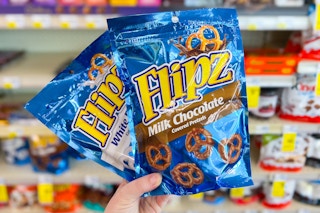 hand holding two bags of flipz pretzels in a store aisle