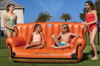 people sitting on an inflatable friends couch sprinkler