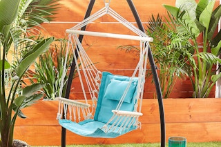 a blue hammock chair hanging up on a stand in someones back yard