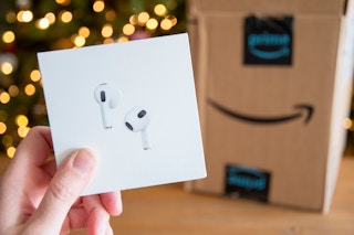 Apple Airpods pro with an amazon box in front of a Christmas tree.