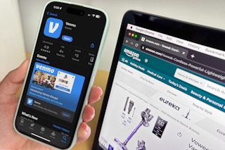 someone holding up a phone showing Venmo next to a laptop displaying Amazon.com