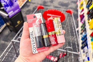 person holding 4 lipsticks over a cart