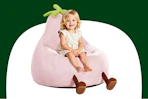 Stock image of a small child sitting in a pink eggplant chair