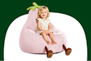 Stock image of a small child sitting in a pink eggplant chair