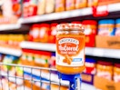 Smuckers Natural Peanut Butter on edge of a Walmart shopping cart