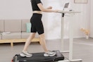 a woman using a walking pad while using a computer