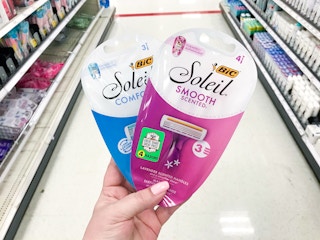 hand holding two packs of BIC razors in store aisle