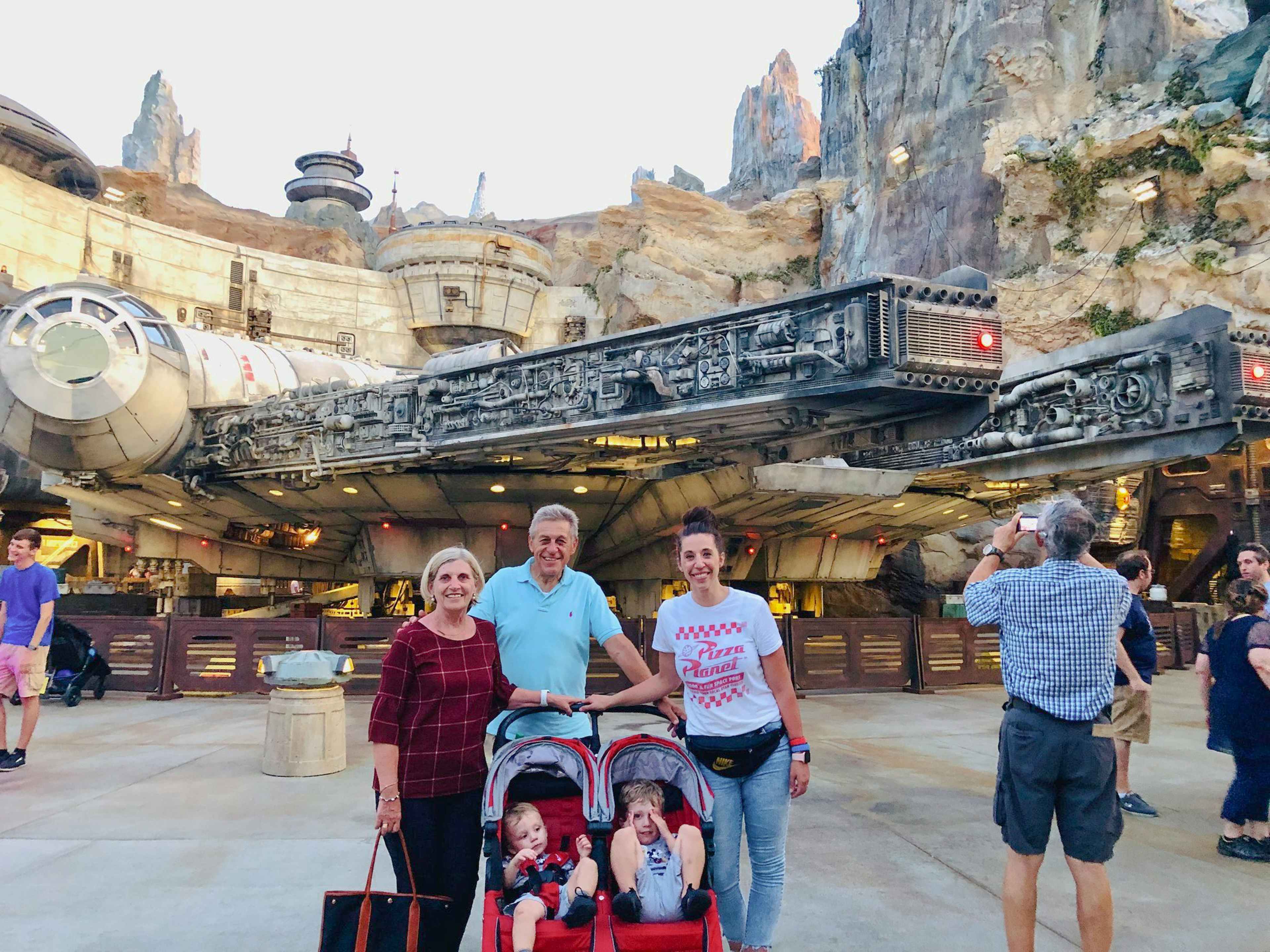 a family standing in front of the star wars area at disney world