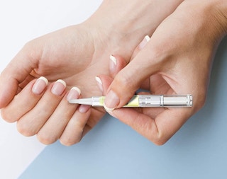 a person applying cuticle oil 