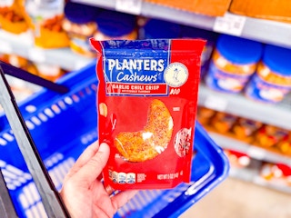 A bag of Planters Cashews held over Walmart shopping basket