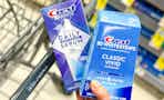 hand holding crest whitestrips and serum by walgreens cart