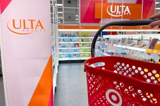 a target hand basket being held in front of ulta sign in the ulta section inside target