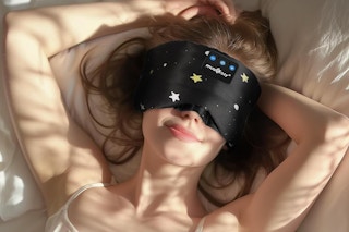 woman laying in bed wearing a sleeping mask