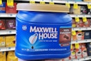 person holding a canister of Maxwell House ground coffee