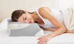 a person laying on a cervical pillow