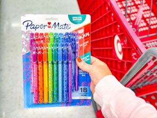 hand holding an 18-pack of paper mate pens in front of a target cart