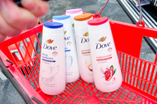 person holding a red basket with 5 bottles of dove body wash in it