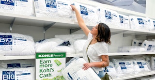 person in kohls reaching for the big one pillows off shelf