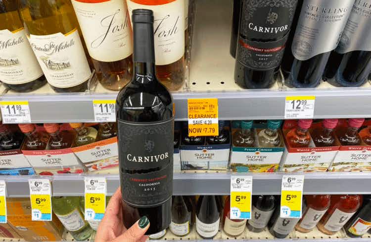 Someone holding a bottle of Carnivor wine inside Walgreens