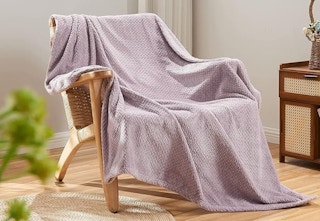 wooden chair in living room with throw blanket spread out on chair