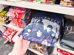 hand grabbing a women's graphic tee off a target shelf