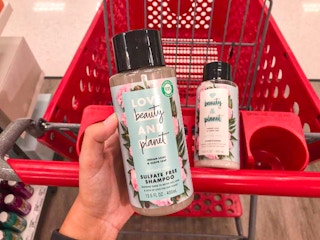 hand holding a bottle of love beauty and planet shampoo at target