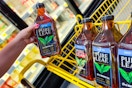 hand holding up a bottle of pure leaf tea next to a yellow shopping cart