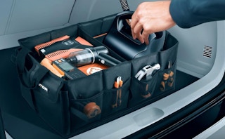 a hand taking an item out of a trunk organizer in a car