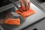 stainless steel cutting board being used to cut fish