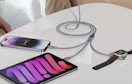 a charging cable charging three devices on a table