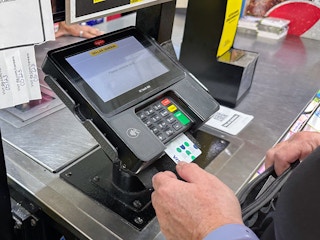 Someone paying at a Dollar General checkout using a card