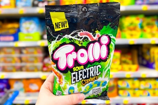hand holding bag of trolli candy in front of store shelf