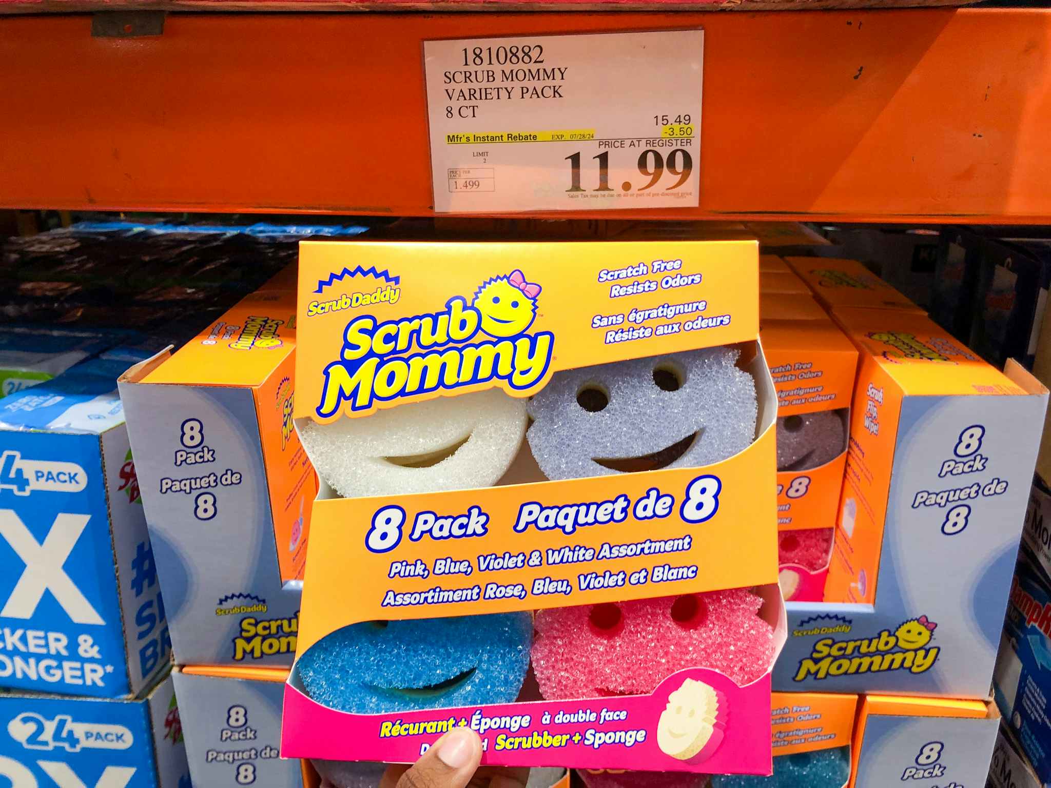 person holding an 8-pack of scrub mommy sponges by a $11.99 sign