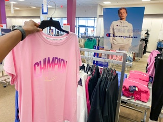 hand holding champion shirt on hanger