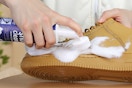person using cleaner on a shoe