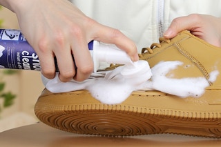 person using cleaner on a shoe