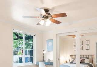 a ceiling fan in a room with the lights on