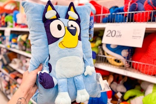 Targey Bluey Pillow Buddy, held up in front of other plush character pillows at Target