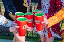 five hands holding up raising canes leprechaun lemonades 