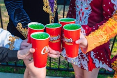 five hands holding up raising canes leprechaun lemonades 