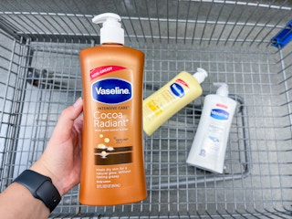 hand holding up Vaseline lotion over the top of a Walmart shopping cart