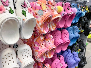 A variety of crocs hanging on a wall at the Croc store