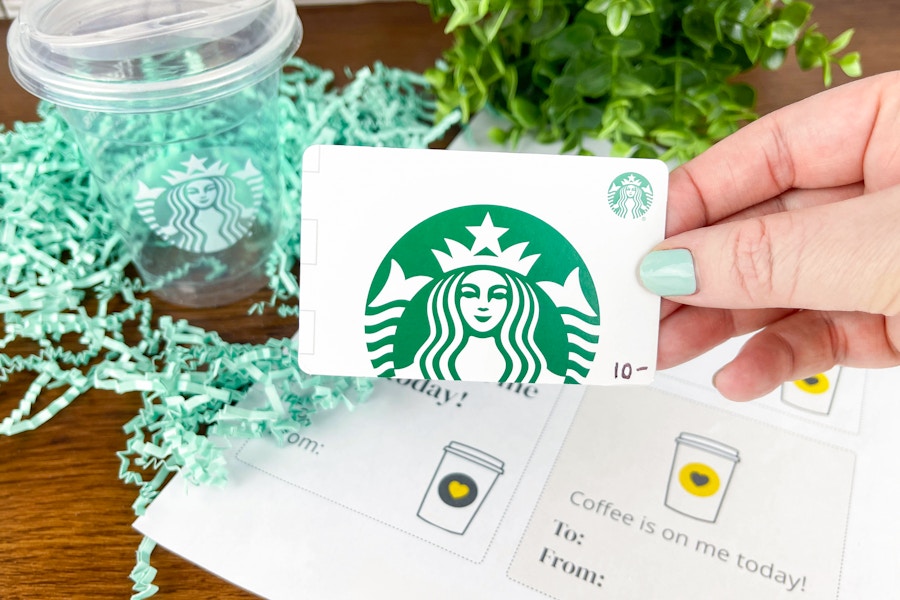 a preson holding a starbucks gift card to make a diy a starbucks coffee teacher gift