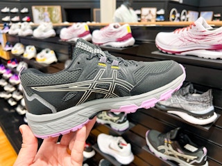 hand holding up asics shoes