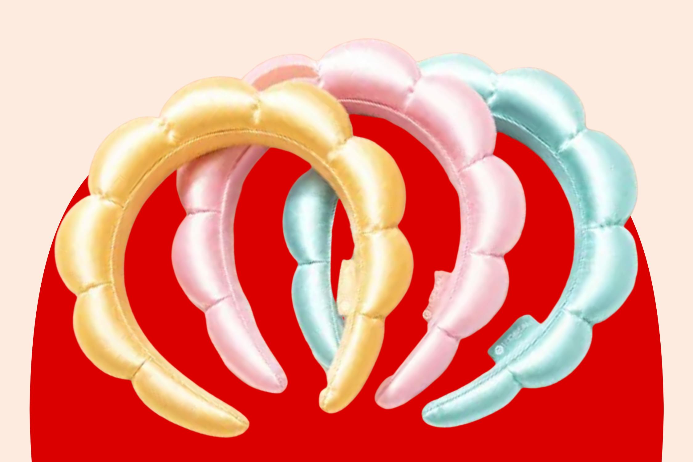 Pastel yellow, pink, and blue bubble headbands arranged on a red background